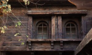 Vieille maison en bois avec des fenêtres et des volets en bois.